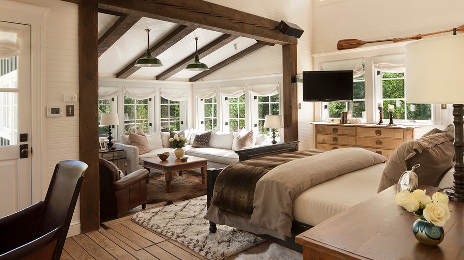 This bedroom in the Main residence has exposed dark beams, a sitting area, and a king sized bed