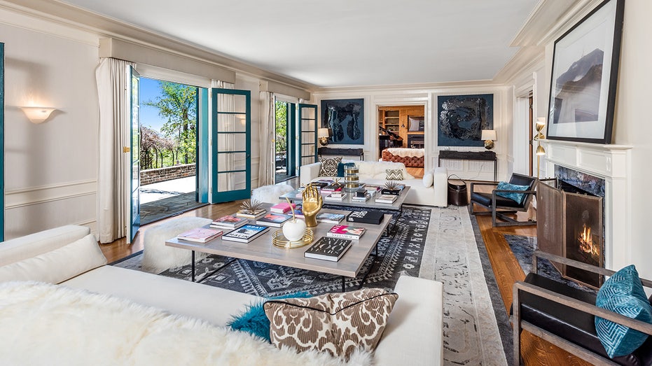 The living space with two mirroring white couches and two massive coffee tables