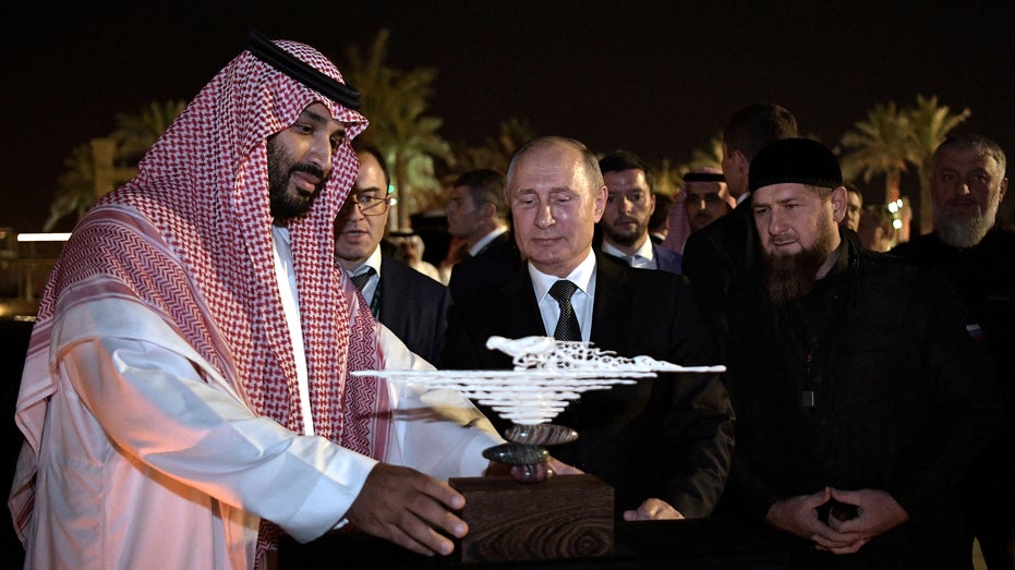 Russian President Vladimir Putin presents a gift made of mammoth tusk to Saudi Arabia's Crown Prince Mohammed bin Salman as head of the Chechen Republic Ramzan Kadyrov looks on in Riyadh