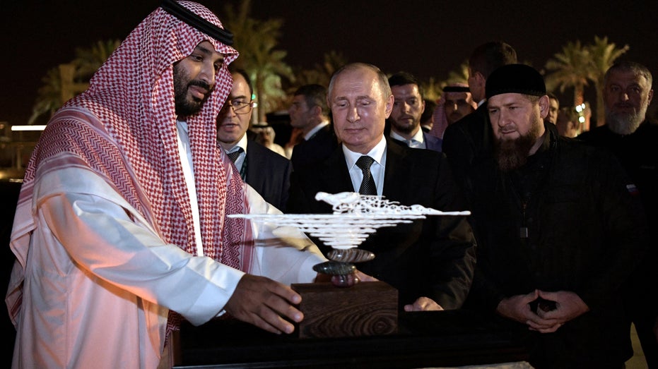 Russian President Vladimir Putin presents a gift made of mammoth tusk to Saudi Arabia's Crown Prince Mohammed bin Salman as head of the Chechen Republic Ramzan Kadyrov looks on in Riyadh