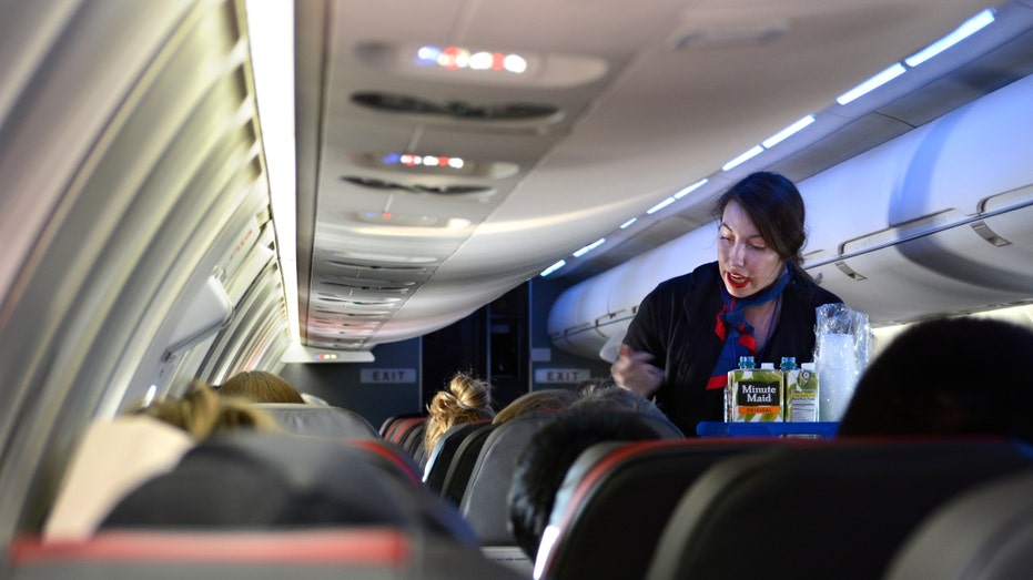 An American Airlines flight attendant serves drinks