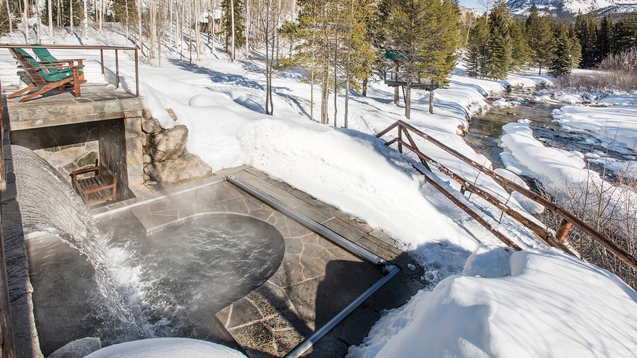 Steam leaves a stone hot tub at one of the residences of Kevin Costner's home with snow around it