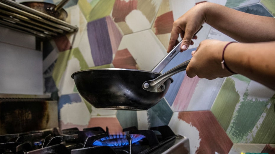 Woman cooks over gas stove