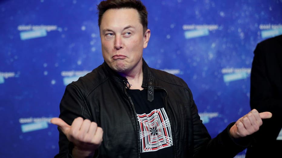 Elon Musk giving a thumbs up on the red carpet