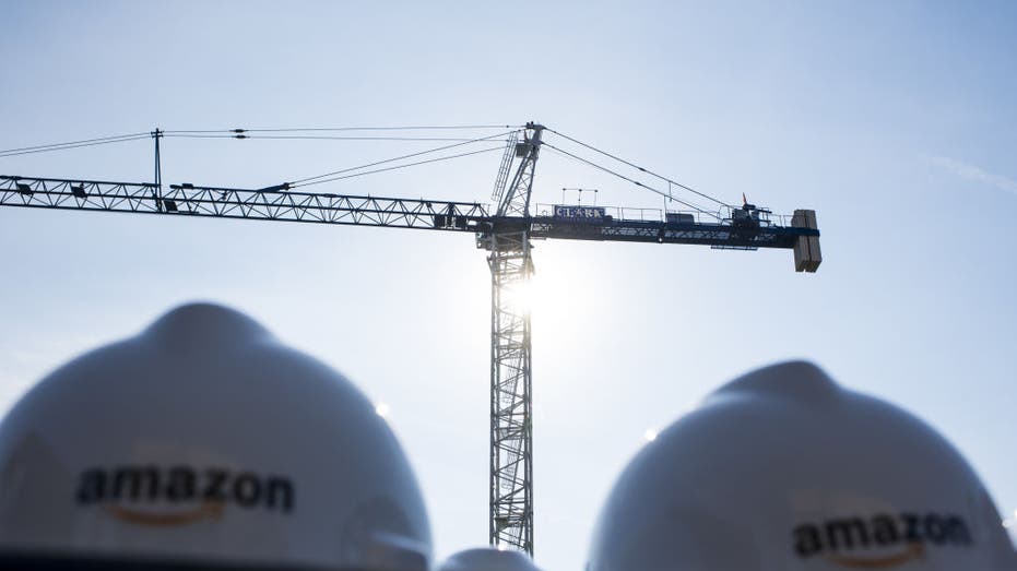 Amazon hard hats in front of a crane