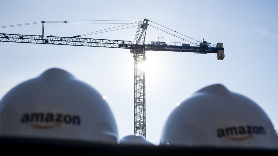 Amazon hard hats in front of a crane