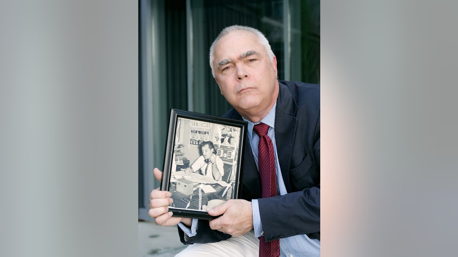 Bernie Madoff victim holding a photo of his father