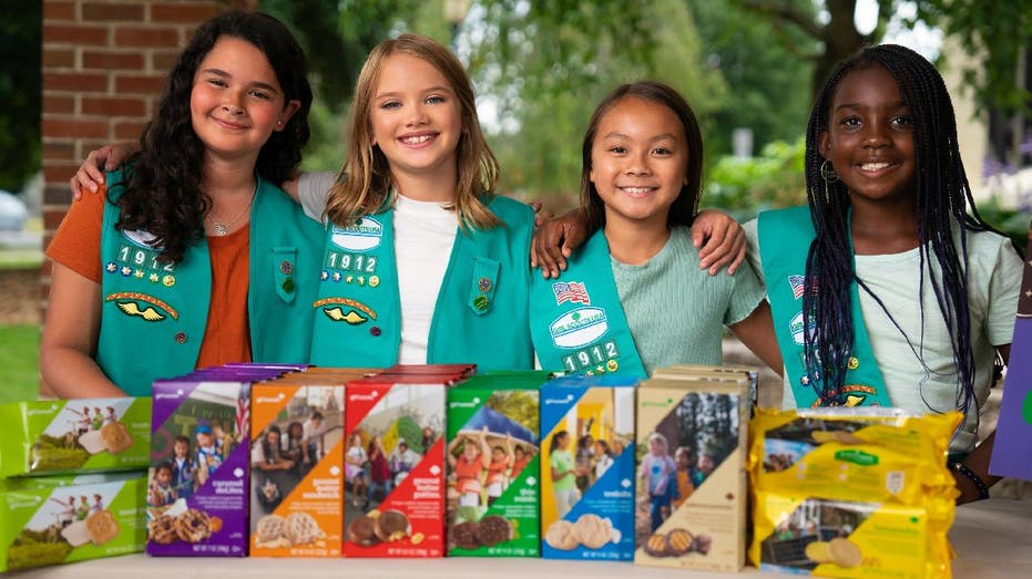 Girl Scouts stand at a sales booth