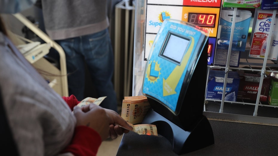 A woman checks her Powerball lottery tickets