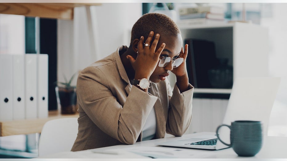 Employee with stressed expression at desk 