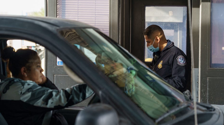 A Customs and Border Protection agent checks a woman's documents at the Paso Del Norte Port of entry in downtown El Paso, Texas