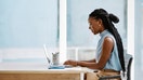 Young black businesswoman working on a laptop in an office alone