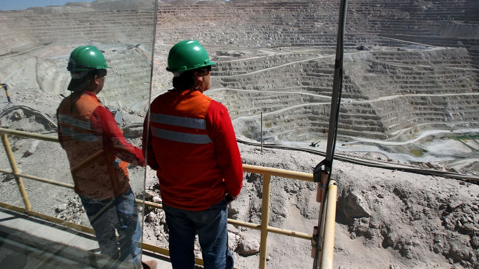 Workers at BHP Billiton's Escondida, the world's biggest copper mine, are seen in front of the open pit, in Antofagasta,