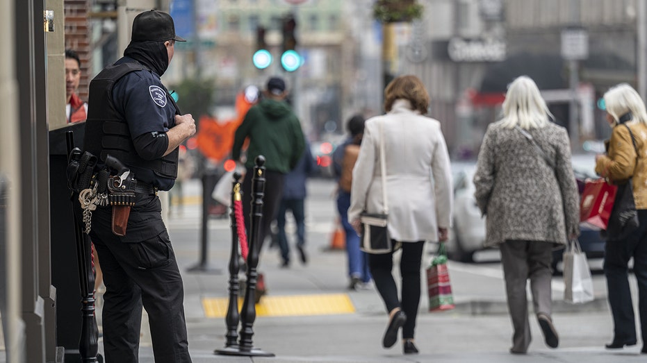 Armed guard stands outside business