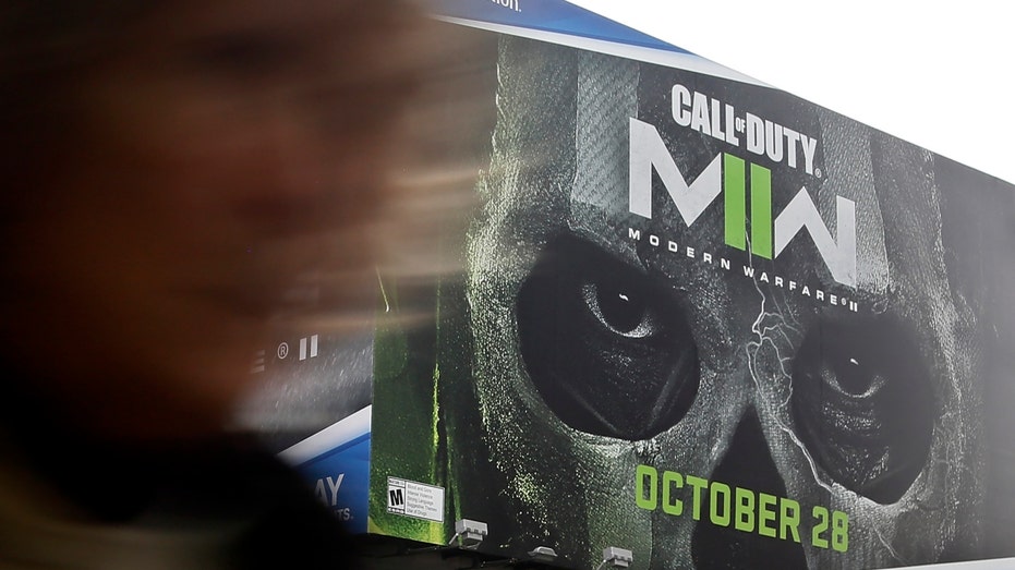 A woman walks near Call of Duty game publicity