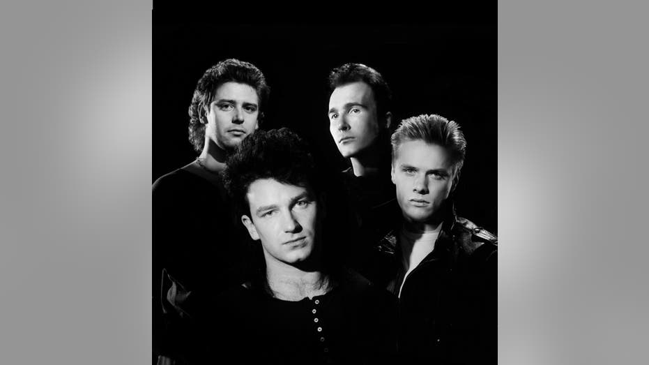 A black and white 1990 protrait of U2, Larry Mullen Jr., The Edge, Bono, and Adam Clayton