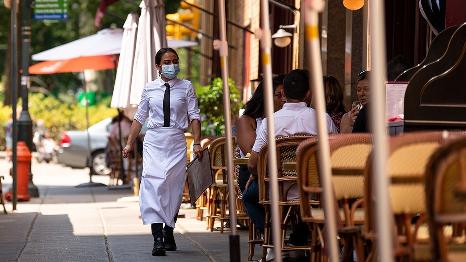 Restaurant server walks by tables