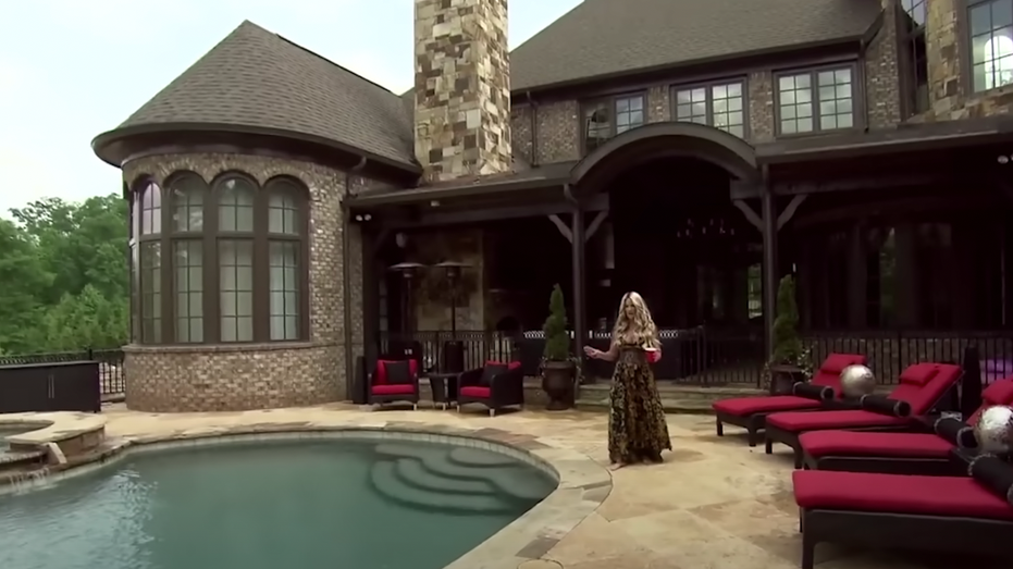 Kim Zolciak walks around the blue pool at her mansion in Georgia