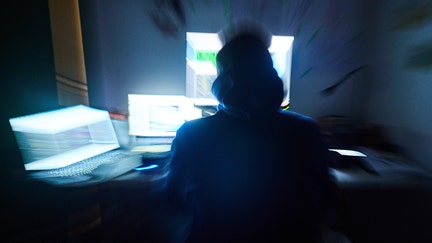 Fictitious html pages and hacker programs are shown on screens while a man has his hands on the keyboard (zoom effect by turning the lens) Photo: Annette Riedl/dpa (Photo by Annette Riedl/picture alliance via Getty Images)