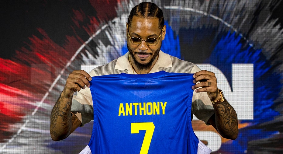 Carmelo Anthony holds up jersey