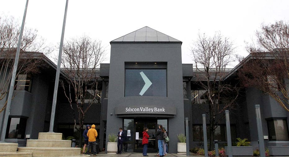 People gather outside of the Silicon Valley Bank (SVB) headquarters