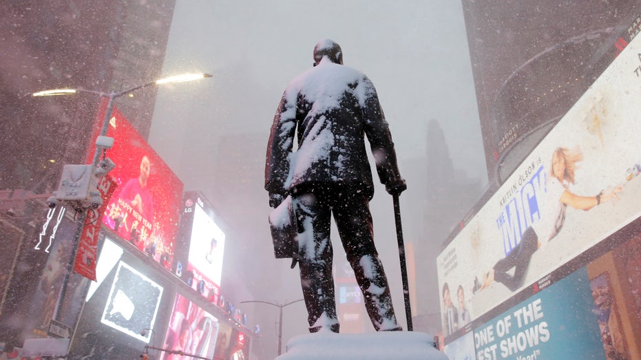 A statue of American composer, playwright, actor, and producer George M. Cohan stands in Times Square as snow falls in Manhattan
