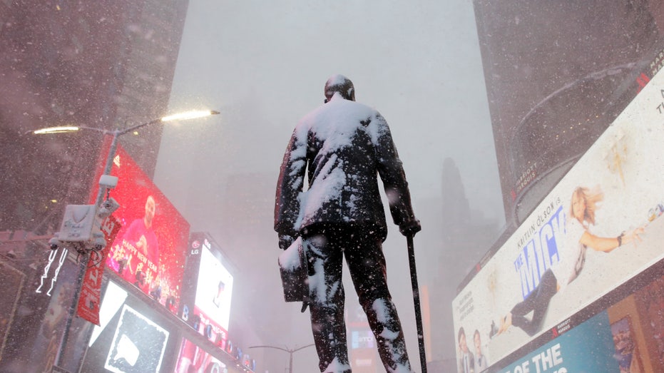 A statue of American composer, playwright, actor, and producer George M. Cohan stands in Times Square as snow falls in Manhattan