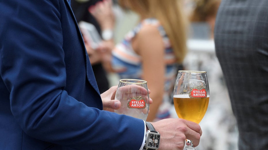 Racegoers drinks Stella Artois beer at the Ascot racecourse at Ascot