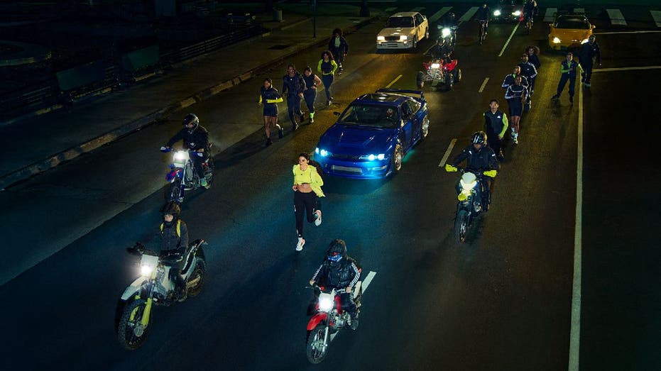 Group of women run together alongside cars and motorcycles in this Adidas ad