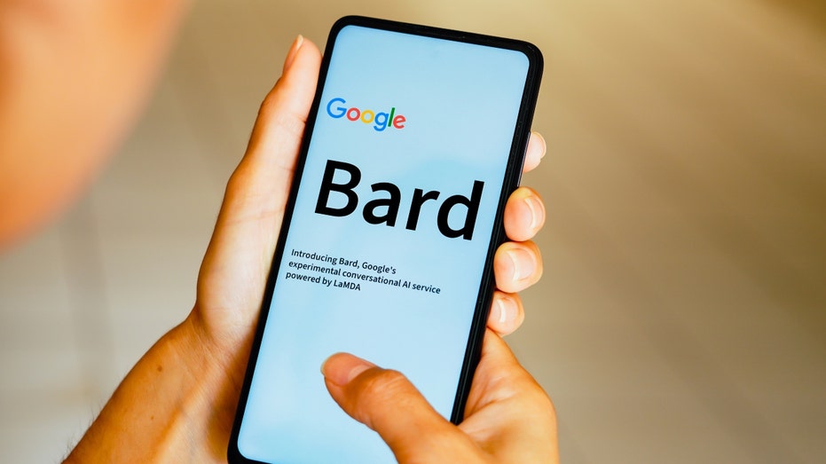 A man's hands hold a smartphone with the Bard logo