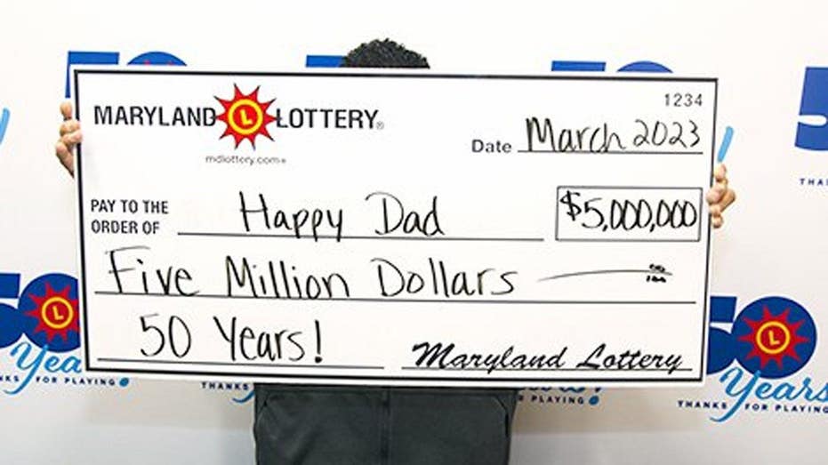 The Happy Dad poses behind a $5 million-dollar check