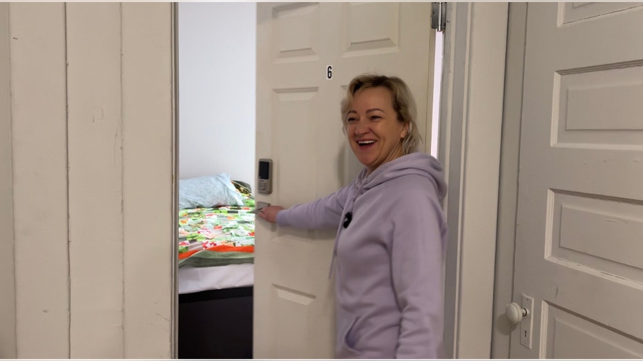 A Ukrainian refugee shows off her new room in America.