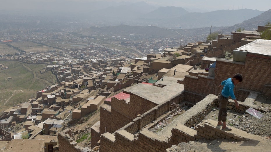 A boy flies a kite on the outskirts of Kabul