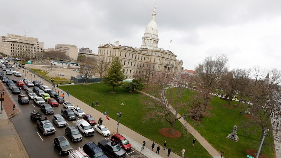 People in cars outside the Michigan State Capitol in Lansing.