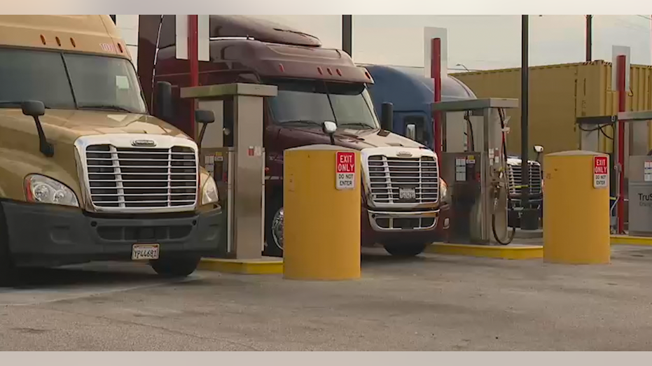 3 big rigs parked at a gas station filling up