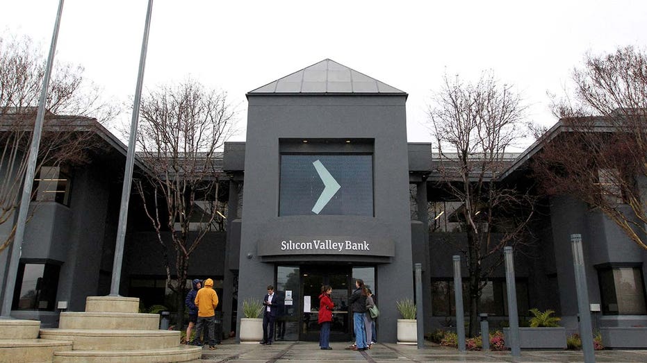 People gather outside of the Silicon Valley Bank (SVB) headquarters