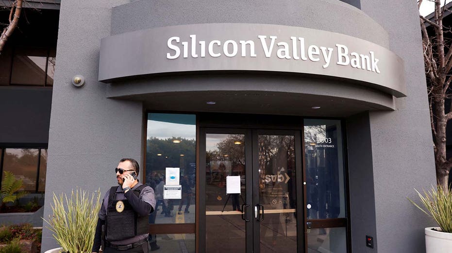 A security guard stands outside of the entrance of the Silicon Valley Bank headquarters