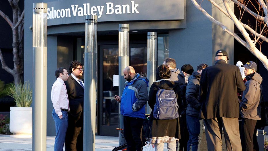 FDIC representatives Luis Mayorga and Igor Fayermark speak with customers outside of the Silicon Valley Bank headquarters