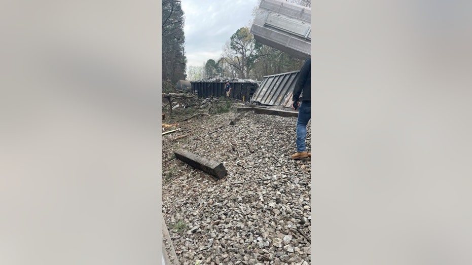 A man surveils the Alabama Norfolk Southern train derailment