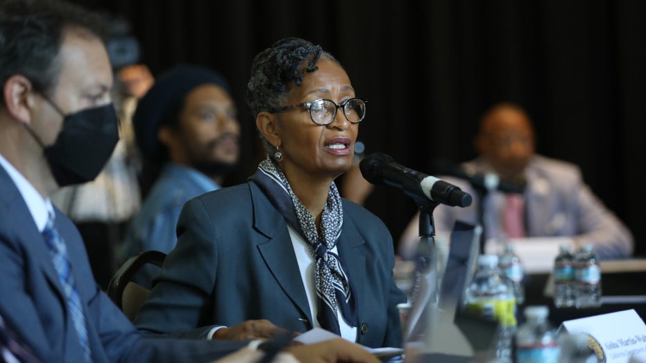 Aisha Martin-Walton, of the California Department of Justice, center, and Michael Newman, Senior Assistant Attorney General of California, left, attend the California Reparations Task Force meeting to hear public input on reparations at the California Science Center in Los Angeles on Sept. 22, 2022