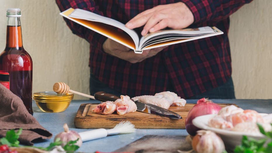 Man holds open cookbook