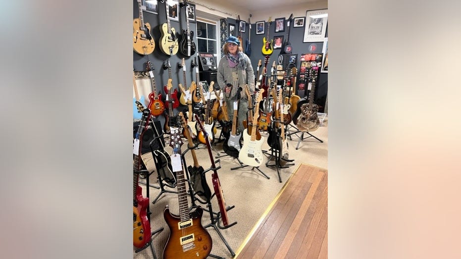 Johnny Depp standing in front of several guitars