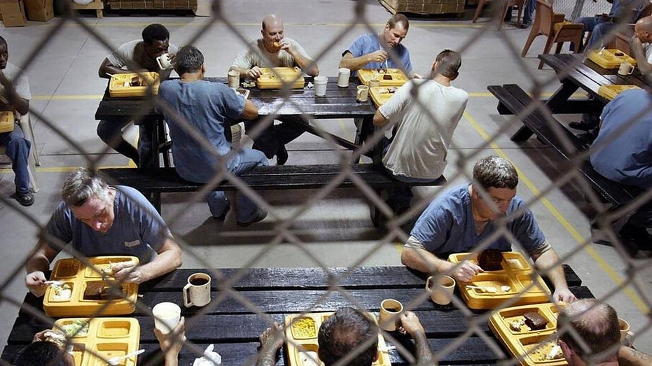 prisoners eat lunch behind bars