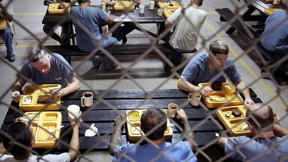 prisoners eat lunch behind bars