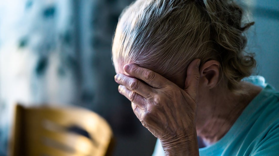 elderly woman head in hand