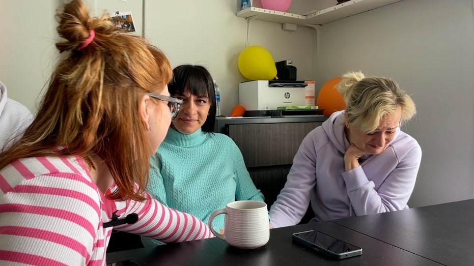 Three Ukrainian refugees comfort each other after getting emotional telling their stories