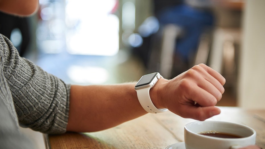 WOMAN CHECKS APPLE WATCH