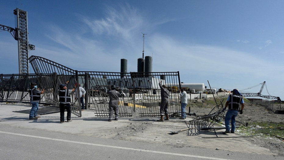 Workers replace fencing on SpaceX's launchpad