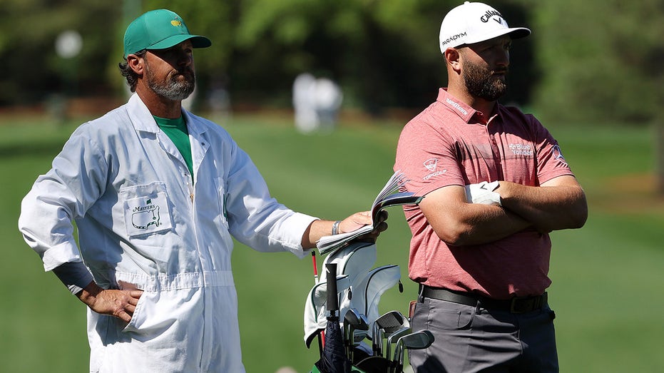 Jon Rahm talks to his caddie