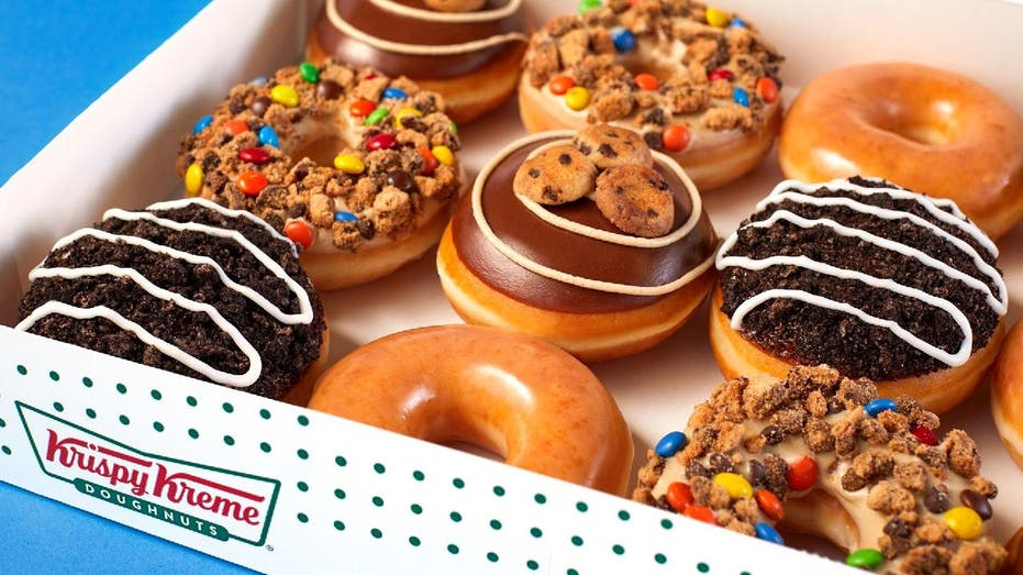 Krispy Kreme's 'Cookie Blast!' doughnuts mixed with Original Glazed doughnuts in a contained dozen box.